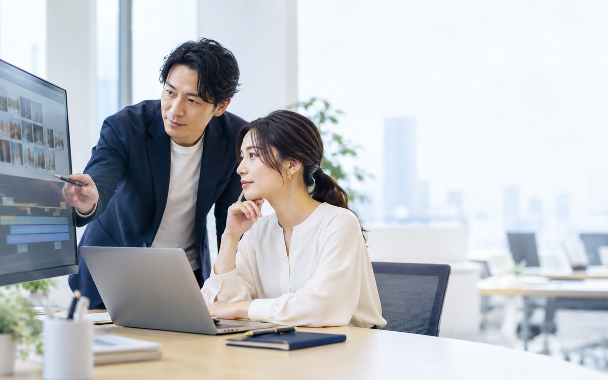 メディア企業のオフィスで、リリース予定を確認する2人(イメージ)